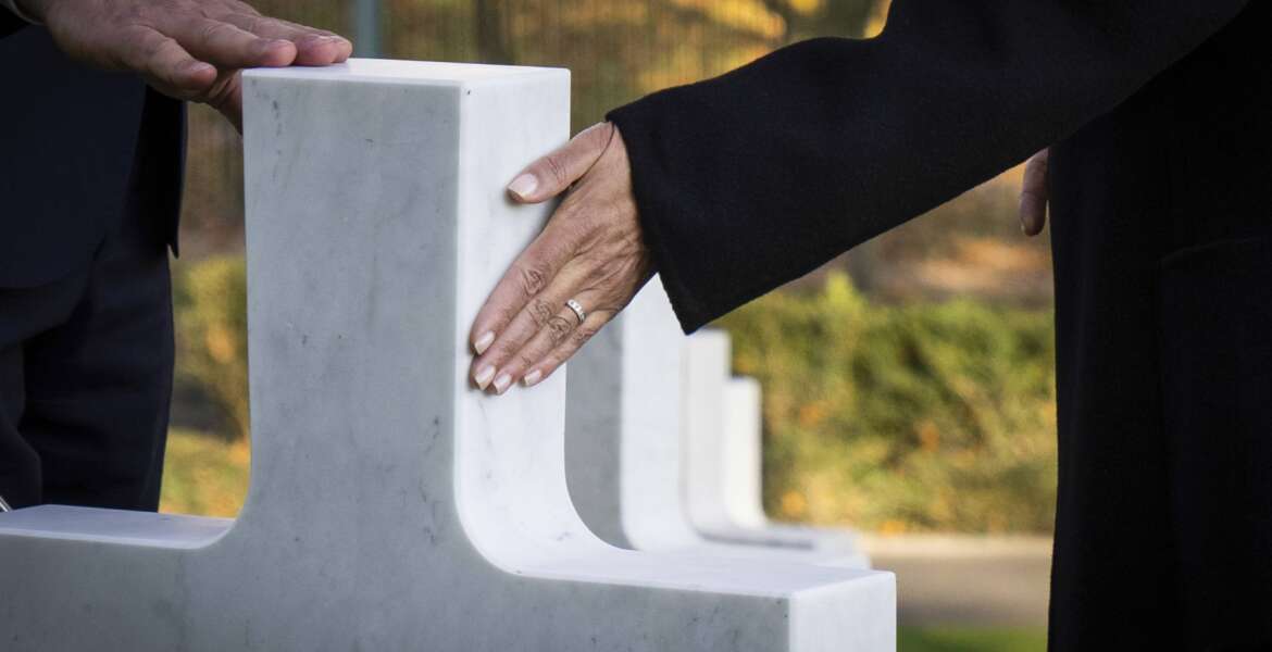 Superintendent Keith Stadler, left, and Vice President Kamala Harris touch a headstone belonging to Inez Crittenden during a tour of Suresnes American Cemetery in Suresnes, France on Wednesday, Nov. 10, 2021. Inez Crittenden of Oakland, Calif., led a team of 232 bilingual switchboard operators known as the 