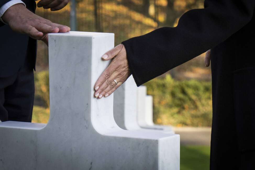 Superintendent Keith Stadler, left, and Vice President Kamala Harris touch a headstone belonging to Inez Crittenden during a tour of Suresnes American Cemetery in Suresnes, France on Wednesday, Nov. 10, 2021. Inez Crittenden of Oakland, Calif., led a team of 232 bilingual switchboard operators known as the "Hello Girls," who made over 26 million calls by the war's end and vital to American success in Europe. With the passage of the 1977 G.I. Improvement Bill, the headstone has subsequently changed from "civilian" to "Chief Operator of the Signal Corps," reflecting her military rank.  (Sarahbeth Maney/The New York Times via AP, Pool)