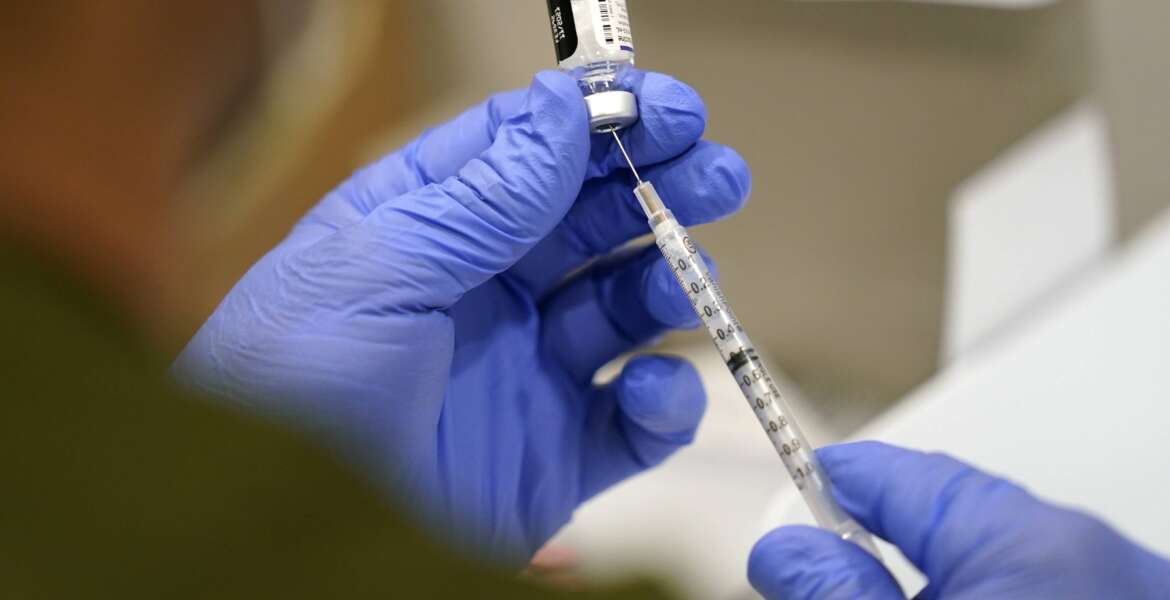 FILE - A healthcare worker fills a syringe with the Pfizer COVID-19 vaccine at Jackson Memorial Hospital, Oct. 5, 2021, in Miami. Nearly 8,500 active duty members of the Air Force and Space Force have missed the deadline for getting COVID-19 vaccinations, including 800 who flatly refused and nearly 5,000 with pending requests for a religious exemption, the Air Force said Wednesday, Nov. 3. (AP Photo/Lynne Sladky, File)
