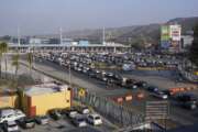 Cars wait to cross into the United States at the San Ysidro Port of Entry, Monday, Nov. 8, 2021, in Tijuana, Mexico. The U.S. fully reopened its borders with Mexico and Canada on Monday and lifted restrictions on travel that covered most of Europe, setting the stage for emotional reunions nearly two years in the making and providing a boost for the travel industry decimated by the pandemic. (AP Photo/Gregory Bull)