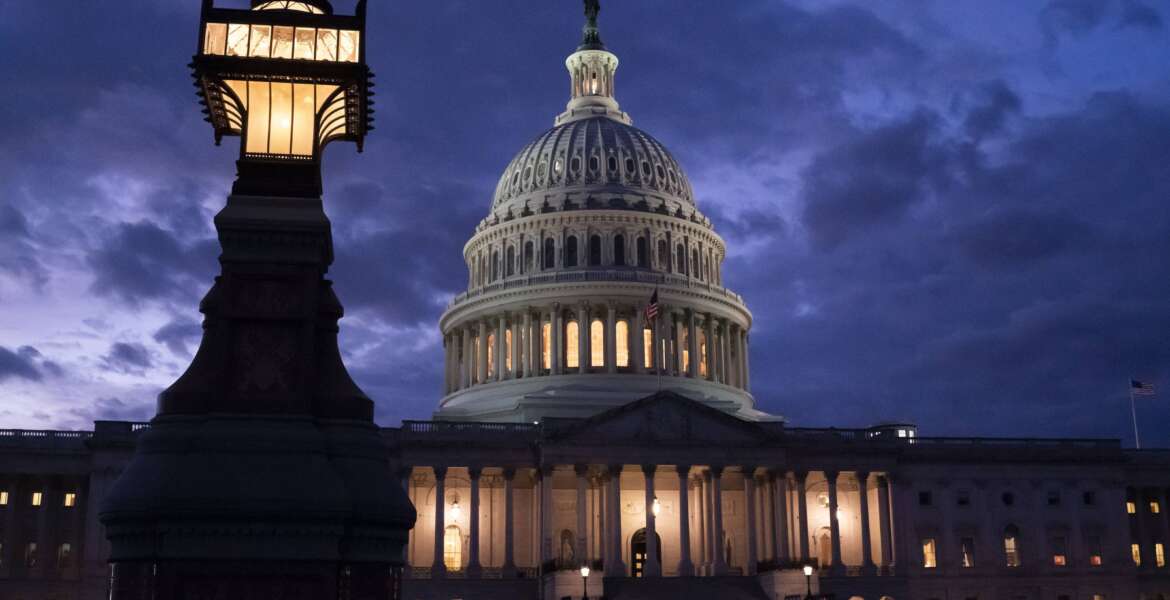 Night falls at the the Capitol in Washington, Thursday, Dec. 2, 2021, with the deadline to fund the government approaching. Republicans in the Senate are poised to stall a must-pass funding bill as they force a debate on rolling back the Biden administration's COVID-19 vaccine mandates for some workers. (AP Photo/J. Scott Applewhite)
