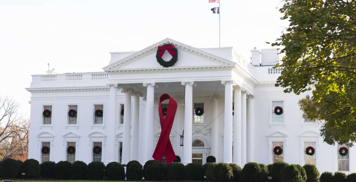 The North Portico of the White House is adorned with a huge red ribbon to commemorate the annual World AIDS Day, Wednesday, Dec. 1, 2021, in Washington. The Biden administration in its new HIV/AIDS strategy is calling racism 
