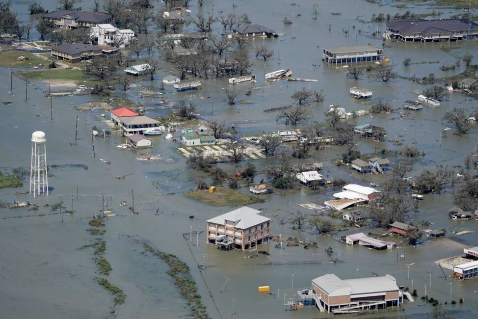 FILE - In this Aug. 27, 2020, file photo, buildings and homes are flooded in the aftermath of Hurricane Laura near Lake Charles, La. In the past year, the southwestern Louisiana city of Lake Charles weathered two hurricanes, intense rainfall that sent water gushing down streets and a deep freeze that burst pipes. Under a revamped federal flood insurance program rolled out in the fall of 2021, millions of homeowners are set for rate hikes that officials say more accurately reflect a property’s risk. (AP Photo/David J. Phillip, File)