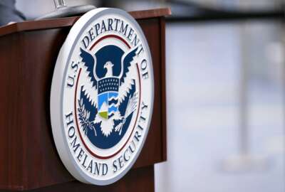 FILE - A U.S. Department of Homeland Security plaque is displayed a podium as international passengers arrive at Miami international Airport where they are screened by U.S. Customs and Border Protection, Nov. 20, 2020, in Miami. A special Customs and Border Protection unit used sensitive government databases intended to track terrorists to investigate as many as 20 U.S.-based journalists, including a Pulitzer Prize-winning Associated Press reporter, according to a federal watchdog. (AP Photo/Lynne Sladky, File)