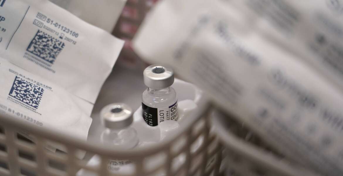 Vials of the Pfizer COVID-19 vaccine ready to be administered, at Swaminarayan School vaccination centre, in London, Saturday, Dec. 4, 2021. Britain says it will offer all adults a booster dose of vaccine within two months to bolster the nation's immunity as the new omicron variant of the coronavirus spreads. New measures to combat variant came into force in England on Tuesday, with face coverings again compulsory in shops and on public transport. (AP Photo/Alberto Pezzali)