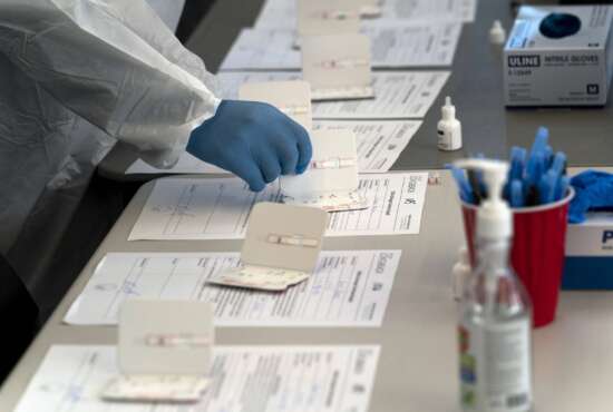 Nurse Ray Akindele processes COVID-19 rapid antigen tests at a testing site in Long Beach , Calif., Thursday, Jan. 6, 2022. (AP Photo/Jae C. Hong)