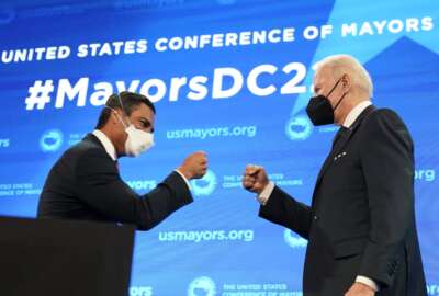 Mayor of Miami Francis Suarez, and president of U.S. Conference of Mayors, knocks knuckles with President Joe Biden after introducing him to speak at the U.S. Conference of Mayors' 90th Annual Winter Meeting at the Capitol Hilton in Washington, Friday, Jan. 21, 2022. (AP Photo/Andrew Harnik)