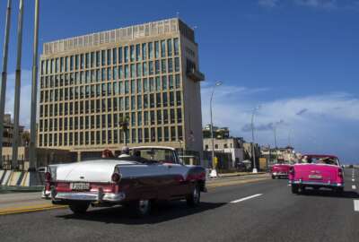 FILE - Tourists ride classic convertible cars on the Malecon beside the United States Embassy in Havana, Cuba, Oct. 3, 2017. The CIA believes it’s unlikely that Russia or another adversary are broadly using directed energy to attack hundreds of U.S. personnel who have reported brain injuries and symptoms that have come to be known as “Havana syndrome.   (AP Photo/Desmond Boylan, File)