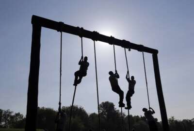 FILE - Freshman midshipmen, known as plebes, climb ropes on an obstacle course during Sea Trials, a day of physical and mental challenges that caps off the freshman year at the U.S. Naval Academy in Annapolis, Md., May 13, 2014. The Navy is adding two weeks to boot camp in a major overhaul aimed at improving recruits' war fighting and emergency skills while also focusing on character issues such as sexual assault, hazing and extremism in the ranks. Navy officials say expanding boot camp to 10 weeks will provide more leadership training and ensure sailors are reporting to their jobs better prepared for duty. (AP Photo/Patrick Semansky, File)