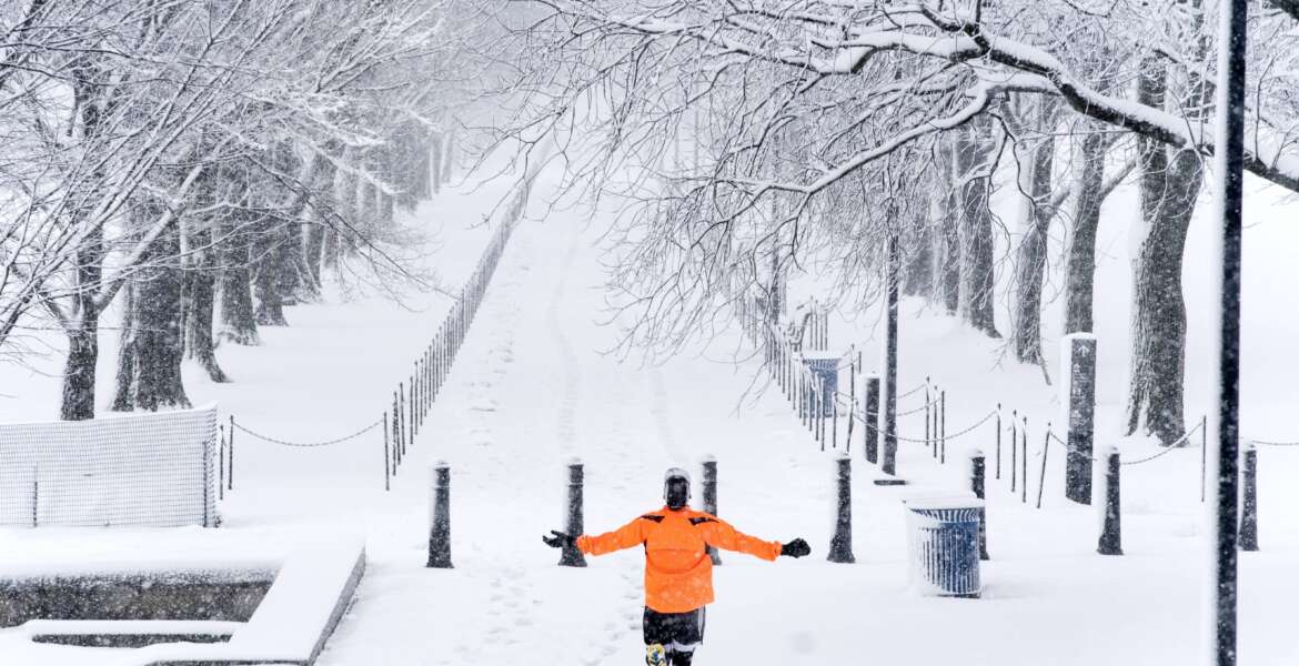 A runner revels in the moment as he jogs along the Lincoln Memorial Reflecting Pool as snow falls, Monday, Jan. 3, 2022, in Washington. (AP Photo/Alex Brandon)