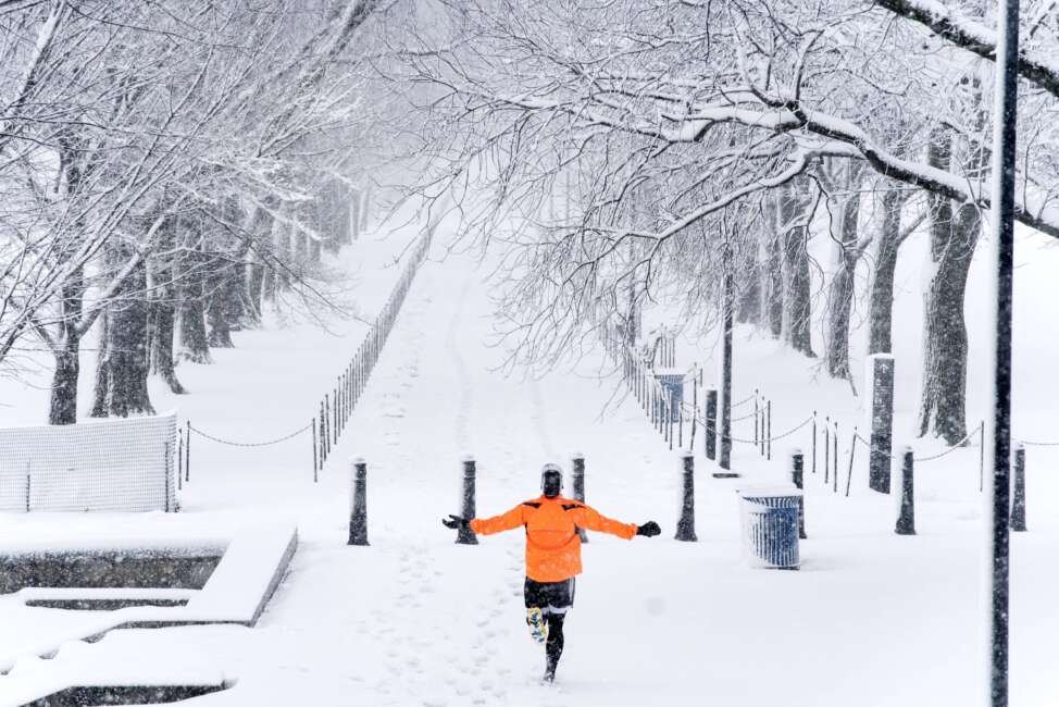 A runner revels in the moment as he jogs along the Lincoln Memorial Reflecting Pool as snow falls, Monday, Jan. 3, 2022, in Washington. (AP Photo/Alex Brandon)