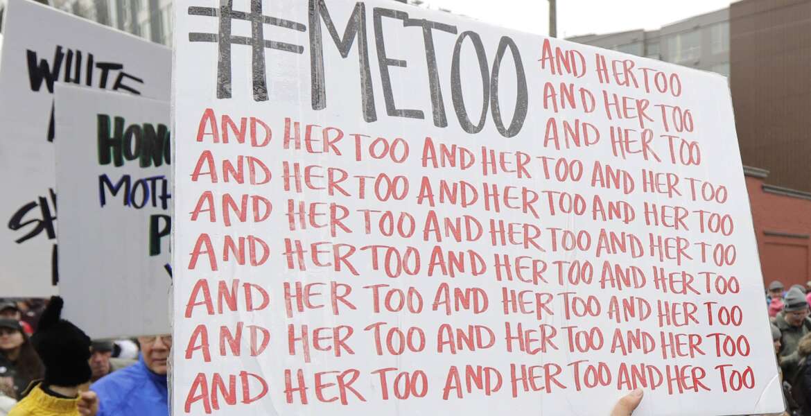 A marcher carries a sign with the popular Twitter hashtag #MeToo used by people speaking out against sexual harassment as she takes part in a Women's March in Seattle.