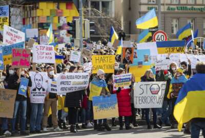 Numerous people demonstrate with signs and flags on Wilhelmsplatz in Stuttgart, Germany, against Russia's military deployment in Ukraine on Saturday, Feb. 26, 2022. (Christoph Schmidt/dpa via AP)