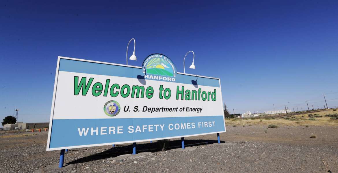 FILE - A sign at the Hanford Nuclear Reservation is posted near Richland, Wash., on Aug. 14, 2019. Workers at the Hanford Nuclear Reservation have started the first large-scale treatment of radioactive and chemical wastes from large underground storage tanks, a key milestone in cleaning up the site. (AP Photo/Elaine Thompson, File)