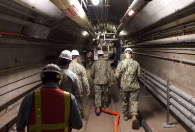In this Dec. 23, 2021, photo provided by the U.S. Navy, Rear Adm. John Korka, Commander, Naval Facilities Engineering Systems Command (NAVFAC), and Chief of Civil Engineers, leads Navy and civilian water quality recovery experts through the tunnels of the Red Hill Bulk Fuel Storage Facility, near Pearl Harbor, Hawaii. The Navy is scrambling to contain what one lawmaker has called a 