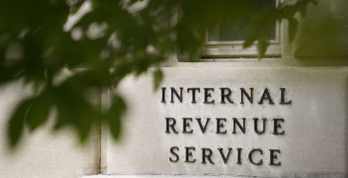 FILE - A sign is displayed outside the Internal Revenue Service building May 4, 2021, in Washington. A private company, enQ, lets those who are willing to pay jump to the front of the line to get their phone calls answered at the IRS. That has attracted the attention of lawmakers who want the IRS to investigate the company's impact on the agency's phone capacity. (AP Photo/Patrick Semansky, File)