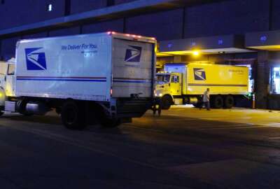 FILE - Delivery trucks arrive at the loading dock at the United States Postal Service sorting and processing facility Nov. 18, 2021, in Boston. The Environmental Protection Agency is raising concerns about a U.S. Postal Service plan to replace its huge fleet of mail-delivery trucks, saying the effort does not include enough electric vehicles. (AP Photo/Charles Krupa, File)