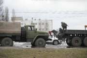 Ukrainian Army soldiers prepare to tow a damaged military truck in Kyiv, Ukraine, Friday, Feb. 25, 2022. Russia is pressing its invasion of Ukraine to the outskirts of the capital after unleashing airstrikes on cities and military bases and sending in troops and tanks from three sides. (AP Photo/Efrem Lukatsky)