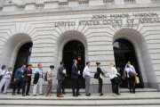 FILE - In this July 9, 2019 file photo, people wait in line to enter the 5th Circuit Court of Appeals in New Orleans. A divided federal appeals court panel in New Orleans ruled Thursday, Feb. 17, 2022 that a pilot and a flight attendant for United Airlines will suffer “irreparable harm” under the airline’s COVID-19 policy that makes them choose between getting vaccinated in violation of their religious objections or going on unpaid leave. The 5th U.S. Circuit Court of Appeals’ 2-1 ruling doesn’t block the airline's mandate. But it says a lower court judge in Texas must consider temporarily blocking the requirement for the employees while they fight United’s vaccine policy. (AP Photo/Gerald Herbert, File)