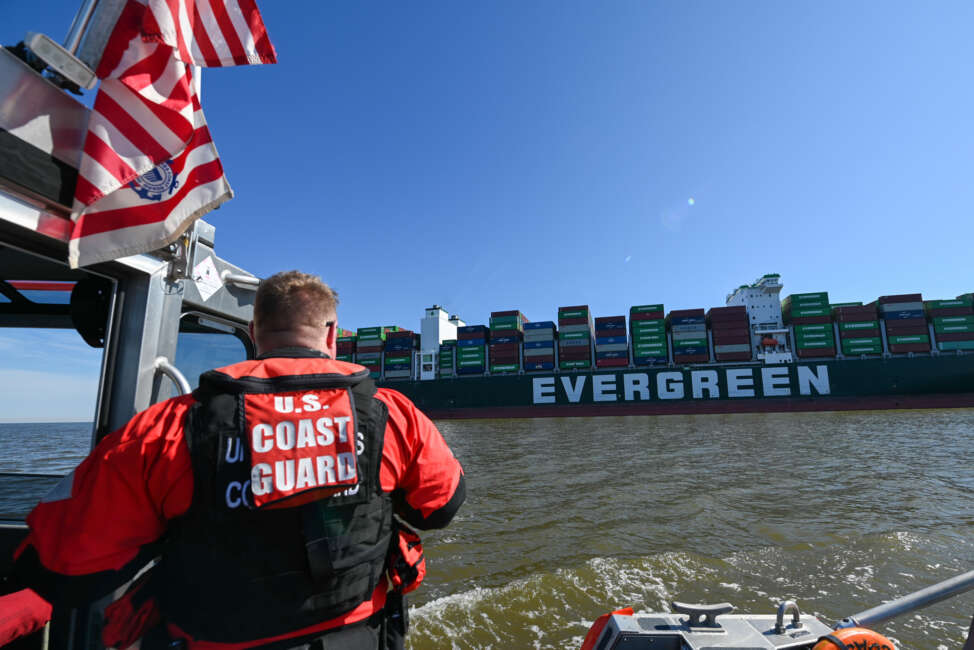 A response boatcrew from Coast Guard Station Curtis Bay monitors the 1,095-foot motor vessel Ever Forward, which became grounded in the Chesapeake Bay, March 13, 2022. The Coast Guard and Maryland Department of the Environment are coordinating the refloating of the container ship.  (U.S. Coast Guard photo by Petty Officer 3rd Class Kimberly Reaves/Released)