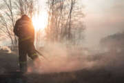 Raging forest spring fires. Burning dry grass, reed along lake. Grass is burning in meadow. Ecological catastrophy. Fire and smoke destroy all life. Firefighters extinguish Big fire. Lot of smok