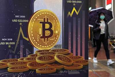 FILE - An advertisement for Bitcoin cryptocurrency is displayed on a street in Hong Kong, Thursday, Feb. 17, 2022. Bitcoin prices have surged in recent days, Wednesday, March 2,  as investors once again appear to view the volatile cryptocurrency as safe haven for their money in the midst of rising geopolitical tensions. (AP Photo/Kin Cheung, File)