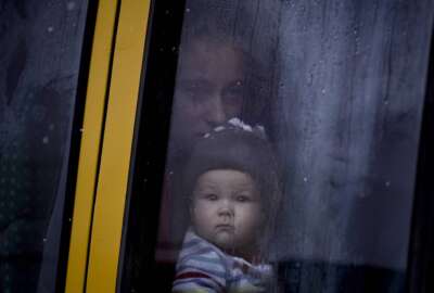 A woman and child who were evacuated from areas on the outskirts of the Ukrainian capital look out the window of a bus after arriving at a triage point in Kyiv, Ukraine, Wednesday, March 9, 2022. A Russian airstrike devastated a maternity hospital Wednesday in the besieged port city of Mariupol amid growing warnings from the West that Moscow's invasion is about to take a more brutal and indiscriminate turn. (AP Photo/Vadim Ghirda)