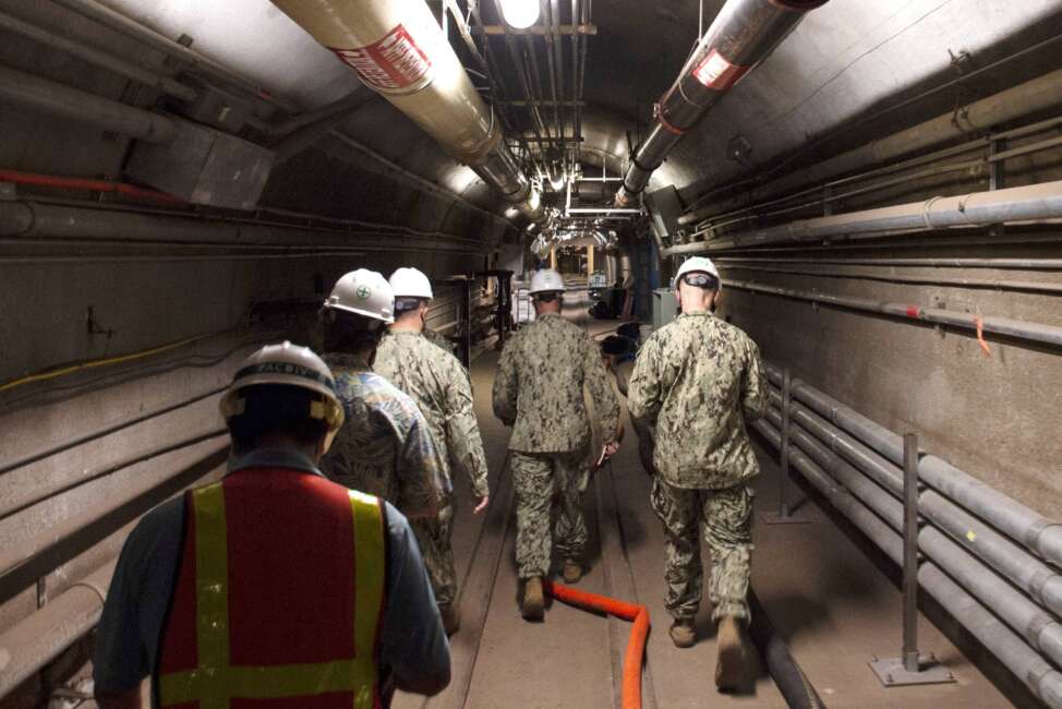 FILE - In this Dec. 23, 2021, photo provided by the U.S. Navy, Rear Adm. John Korka, Commander, Naval Facilities Engineering Systems Command (NAVFAC), and Chief of Civil Engineers, leads Navy and civilian water quality recovery experts through the tunnels of the Red Hill Bulk Fuel Storage Facility, near Pearl Harbor, Hawaii. Native Hawaiians who revere water in all its forms as the embodiment of a Hawaiian god say the Navy's acknowledgement that jet fuel leaked into Pearl Harbor's tap water has deepened the distrust they feel toward the U.S. military. (Mass Communication Specialist 1st Class Luke McCall/U.S. Navy via AP, File)