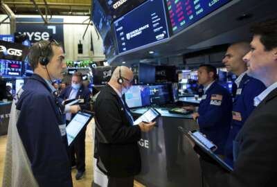 In this photo provided by the New York Stock Exchange, traders gather at a post on the floor, Wednesday, April 13, 2022. Stocks rose in afternoon trading on Wall Street Wednesday as investors reviewed the latest round of corporate earnings and an upbeat report from Delta Air Lines that bodes well for the broader travel industry. (Courtney Crow/New York Stock Exchange via AP)