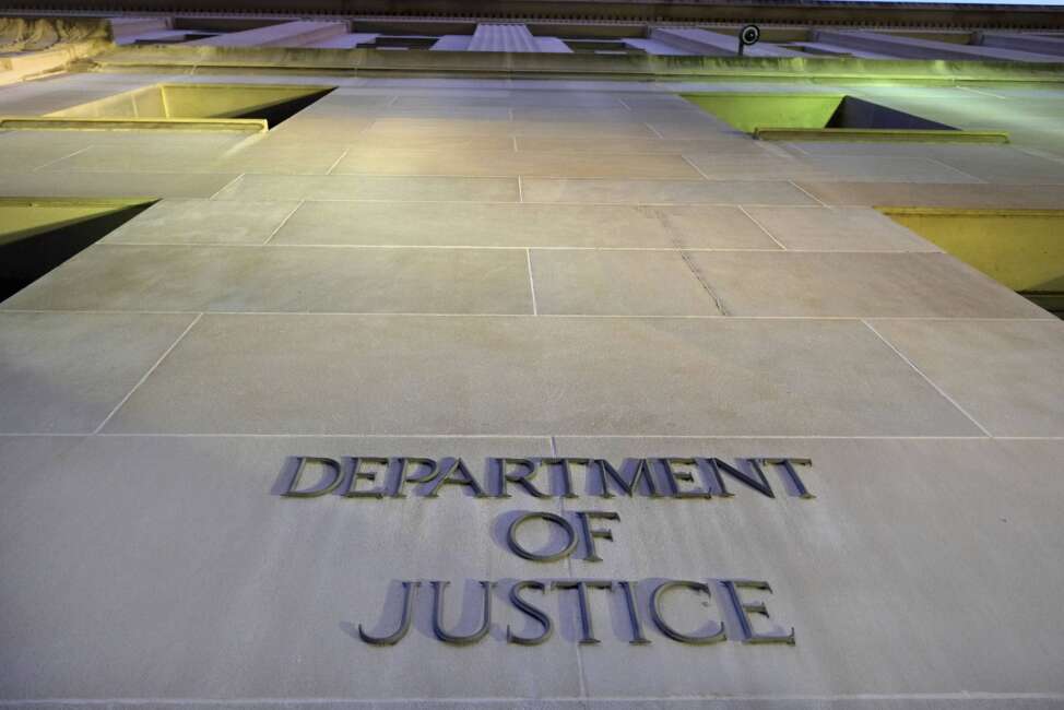 FILE - In this May 14, 2013, photo, the Department of Justice headquarters building in Washington is photographed early in the morning. Twelve people, including three U.S. Army soldiers, are accused in a large-scale gun trafficking ring that prosecutors allege supplied nearly 100 guns to gang members in Chicago. Attorney General Merrick Garland announced the indictment on April 1, 2022. (AP Photo/J. David Ake, File)