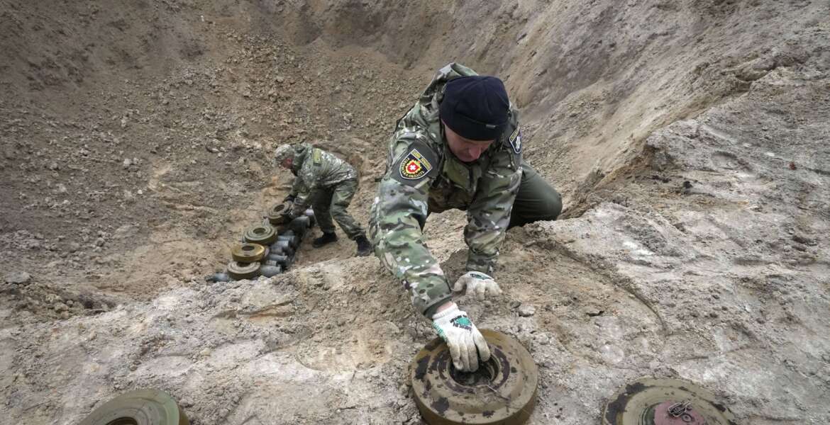 Ukrainian Interior ministry sappers collect explosives in a hole to detonate them near a mine field in the village of Moshchun, close to Kyiv, Ukraine, Tuesday, April 19, 2022. Russia ratcheted up its battle for control of Ukraine’s eastern industrial heartland on Tuesday, intensifying assaults on cities and towns along a front hundreds of miles long in what officials on both sides described as a new phase of the war. (AP Photo/Efrem Lukatsky)