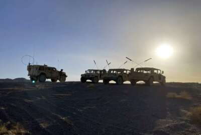 Army vehicles on the ridge, as soldiers from the 2nd Brigade, 1st Cavalry Division, prepare to attack the enemy in the town nearby, during an early morning training exercise at the National Training Center at Fort Irwin, Calif., April 12, 2022. (AP Photo/Lolita C. Baldor)