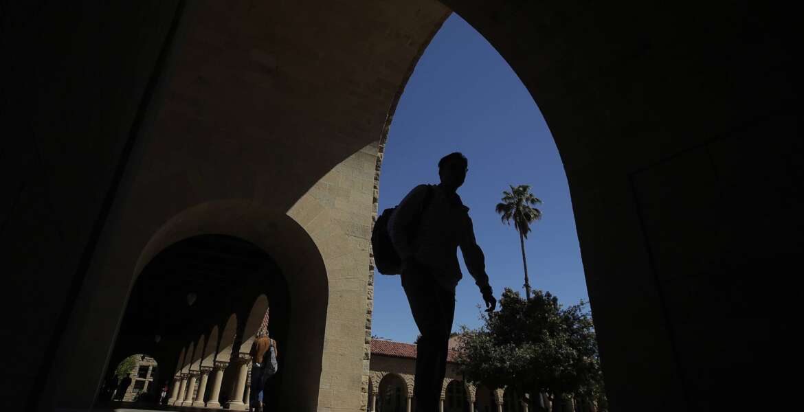 FILE - People walk on the campus at Stanford University in Stanford, Calif. A new federal report finds that record-keeping failures by the Education Department may have left thousands of Americans stuck with student debt that should have been forgiven. A study released Wednesday, April 20, 20220, by the Government Accountability Office revealed flaws in the management of income-driven repayment plans. (AP Photo/Jeff Chiu, File)