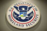 The Homeland Security logo is seen during a joint news conference in Washington, Feb. 25, 2015. The Homeland Security Department said Friday that Cameroonians would be temporarily shielded from deportation, saying extreme violence between government forces and armed separatists in the African nation made conditions unsafe for people to return. (AP Photo/Pablo Martinez Monsivais, File)