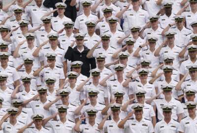 Undergraduate midshipmen salute as they watch the U.S. Naval Academy's graduation and commissioning ceremony at the Navy-Marine Corps Memorial Stadium in Annapolis, Md., Friday, May 27, 2022. (AP Photo/Susan Walsh)
