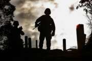 FILE - U.S. Marine Corps Sgt. Mike Anglen of Turner, Ore., center, stands atop a cliff as Sgt. Bryan Wallace of Pikin, Ill., waits for his turn before their rappelling exercise at Jungle Warfare Training Center in Camp Gonsalves, northern Okinawa, Japan, on Feb. 8, 2002. Okinawa on Sunday, May 15, 2022, marks the 50th anniversary of its return to Japan on May 15, 1972, which ended 27 years of U.S. rule after one of the bloodiest battles of World War II was fought on the southern Japanese island. (AP Photo/Junji Kurokawa, File)