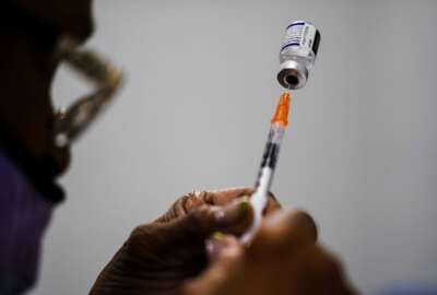FILE - A syringe is prepared with the Pfizer COVID-19 vaccine at a vaccination clinic at the Keystone First Wellness Center in Chester, Pa., Dec. 15, 2021. A federal appeals court is being asked Monday, May 23, 2022, to reconsider its decision allowing the Biden administration to require that federal employees get vaccinated against COVID-19. (AP Photo/Matt Rourke, File)