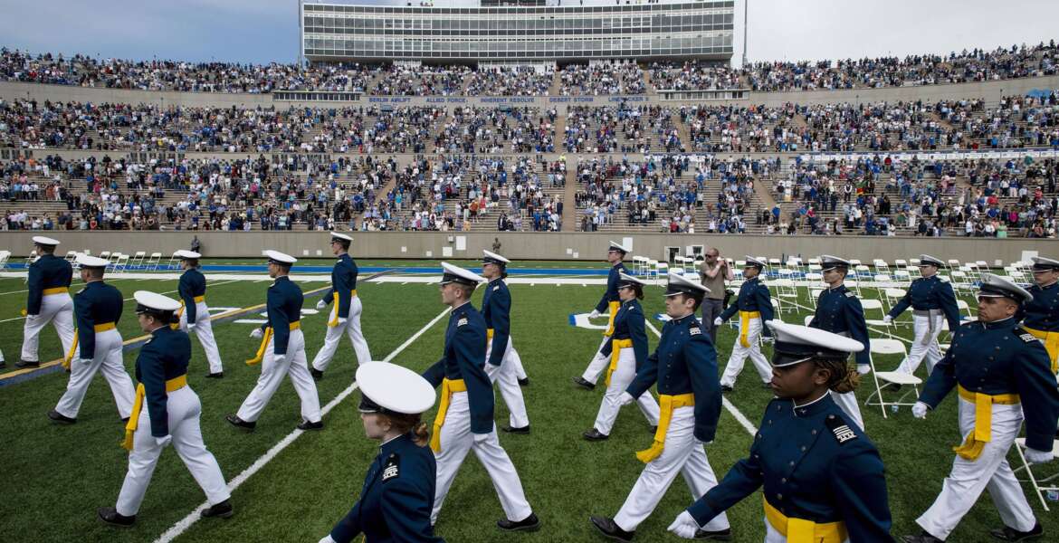FILE - Air Force Academy cadets make their way to their seats as family and friends cheer from the stands during the United States Air Force Academy's Class of 2021 graduation ceremony at the USAFA in Colorado Springs, Colo., on May 26, 2021. Four cadets at the Air Force Academy may not graduate or be commissioned as military officers in May 2022, because they have refused the COVID-19 vaccine, and they may be required to pay back thousands of dollars in tuition costs, according to Air Force officials. (Chancey Bush/The Gazette via AP, File)