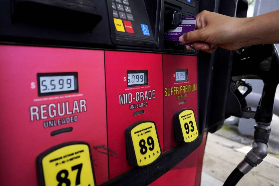 A customer holds a credit card at the pay-at-the-pump gasoline pump in Rolling Meadow, Ill., Thursday, June 30, 2022. U.S consumers have so far defied higher prices for gas, food, and rent and have been spending more in 2022, providing crucial support to the economy. The Wall Street Journal reports that Visa and Mastercard have raised the amount a gas station can hold up to $175 on credit or debit card at the pump. (AP Photo/Nam Y. Huh)