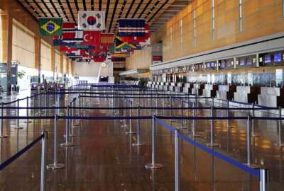FILE - Flags of countries of the world hang over an empty Terminal E, at Logan Airport in Boston, Sept. 29, 2020. The Biden administration says it will spend nearly $1 billion to upgrade airports around the country. The Federal Aviation Administration said Thursday that the money will go to 85 different airports. (AP Photo/Charles Krupa, File)