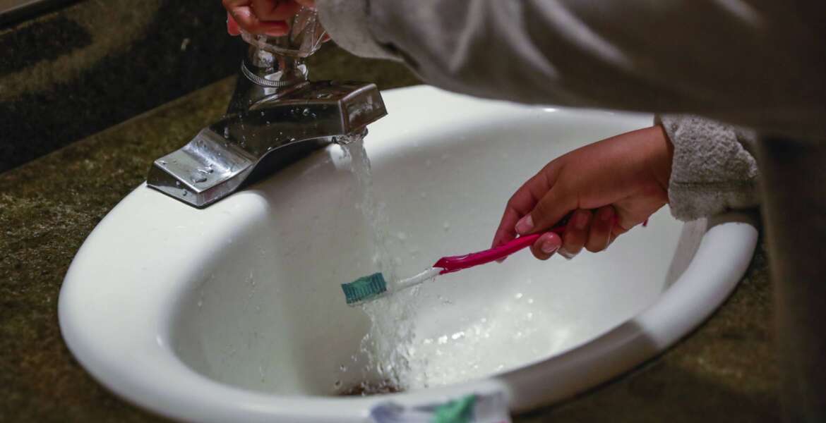 FILE - A child rinses a toothbrush at a shelter in San Francisco, Calif., June 18, 2019. Tap water is subject to a rash of government standards but people in many communities across the U.S. remain exposed to unhealthy drinking water. A Supreme Court decision on EPA regulation of carbon emissions from power plants this past week could make it harder to expand federal regulation in other areas. (Gabrielle Lurie/San Francisco Chronicle via AP, File)