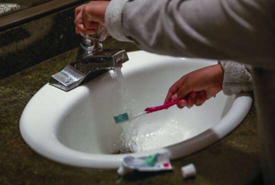 FILE - A child rinses a toothbrush at a shelter in San Francisco, Calif., June 18, 2019. Tap water is subject to a rash of government standards but people in many communities across the U.S. remain exposed to unhealthy drinking water. A Supreme Court decision on EPA regulation of carbon emissions from power plants this past week could make it harder to expand federal regulation in other areas. (Gabrielle Lurie/San Francisco Chronicle via AP, File)