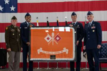 Army Lt. Gen. Daniel Karbler (left), commander of the Army Space and Missile Defense Command, presents the 53rd Signal Battalion colors to Space Force Lt. Gen. Stephen Whiting (right), commander of Space Operations Command, during a ceremony at Peterson Space Force Base, Colorado. The passing of the colors signifies the Army satellite communications mission transferring to the Space Force, consolidating all Department of Defense SATCOM functions under one service for the first time. (Space Force/Airman 1st Class Aliviah Williams)