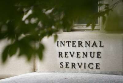 FILE - A sign is displayed outside the Internal Revenue Service building May 4, 2021, in Washington.  On Friday, Aug. 19, 2022, The Associated Press reported on stories circulating online incorrectly claiming an online job ad shows that all new employees that the IRS intends to hire after a funding boost in the Inflation Reduction Act will be required to carry a firearm and use deadly force if necessary.  (AP Photo/Patrick Semansky, File)