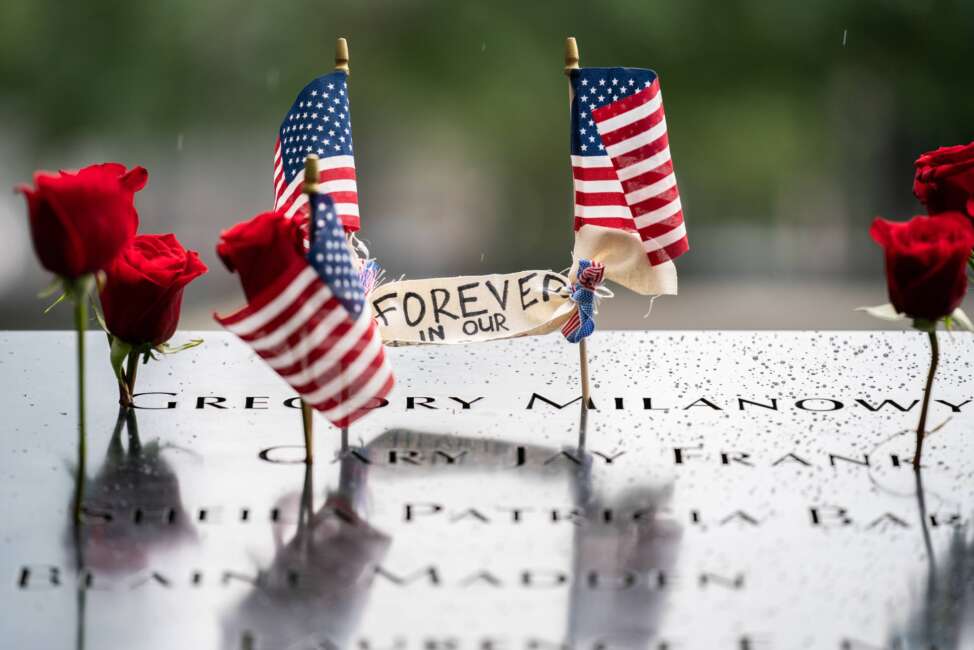 Flowers and flags on the south pool commemorate the 21st anniversary of the Sept. 11 attacks, Sunday, Sept. 11, 2022, at the National September 11 Memorial &amp; Museum in New York. (AP Photo/Julia Nikhinson)