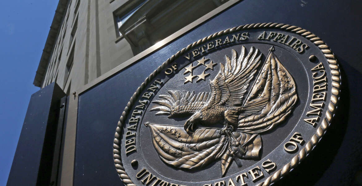 FILE - This June 21, 2013, file photo, shows the seal affixed to the front of the Department of Veterans Affairs building in Washington.  In a federal lawsuit filed this week, U.S. Navy veteran from South Carolina says he ended up with “full-blown AIDS,” because government health care workers never informed him of his positive test result in 1995. He says the test was done as part of standard lab tests at a U.S. Department of Veterans Affairs medical center in Columbia, South Carolina. A V.A. spokeswoman says the agency typically does not comment on pending litigation. (AP Photo/Charles Dharapak, File)