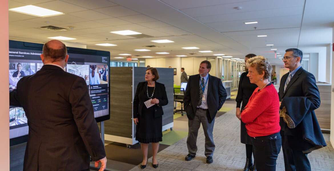 GSA chief architect Chuck Hardy (left) demonstrates the new smart board where users can to make reservations to use specific space or test out the other technologies that support the new Workplace Innovation Lab at the agency’s headquarters building in Washington, D.C(Photo courtesy GSA)