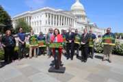 Rep. Katie Porter (D-Calif.), accompanied by federal wildland firefighters and union leaders, speaks to reporters in front of the Capitol building.