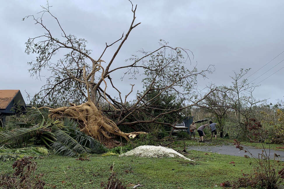 Andy Villagomez clears what remains of a large tree that overshadowed his front yard before falling to Typhoon Mawar, Thursday, May 25, 2023, in Mongmong-Toto-Maite, Guam. (AP Photo/Grace Garces Bordallo)