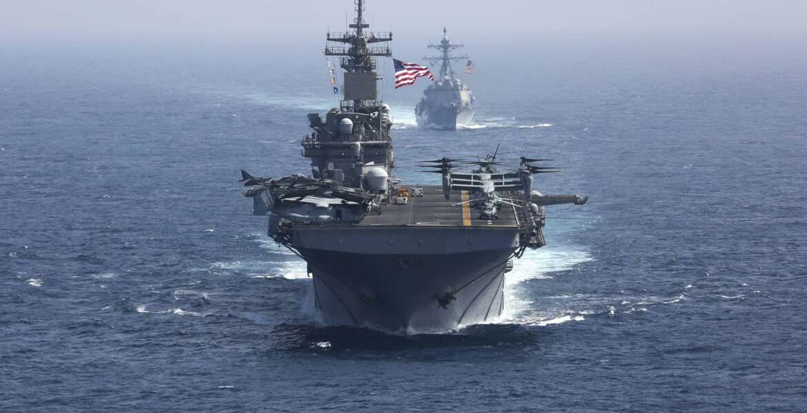 Amphibious assault ship USS Kearsarge and the Arleigh Burke-class guided-missile destroyer USS Bainbridge sail in formation.